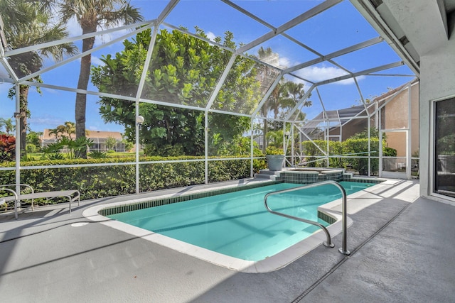 view of pool with a patio area and glass enclosure