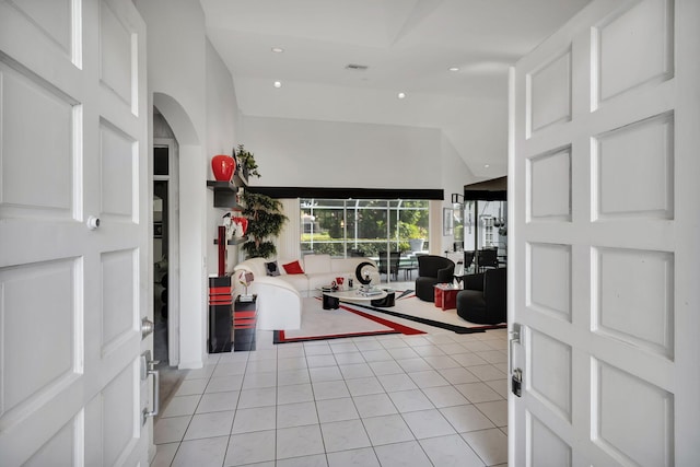 foyer with high vaulted ceiling and light tile patterned floors