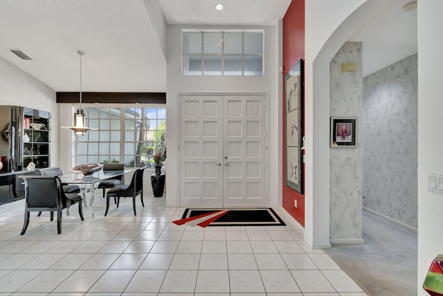 entrance foyer featuring light tile patterned floors and a towering ceiling