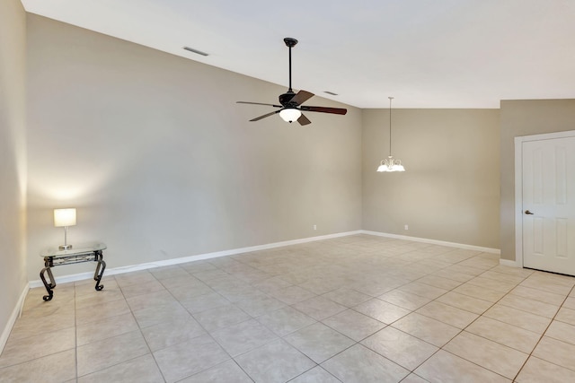 tiled empty room featuring ceiling fan with notable chandelier and lofted ceiling