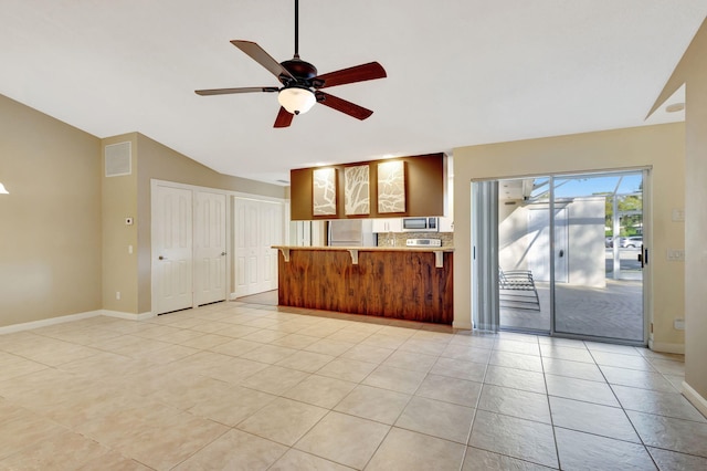 unfurnished living room featuring ceiling fan, lofted ceiling, and light tile patterned flooring