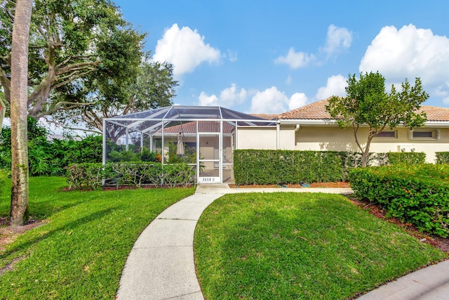 view of front of house with a front yard and a lanai