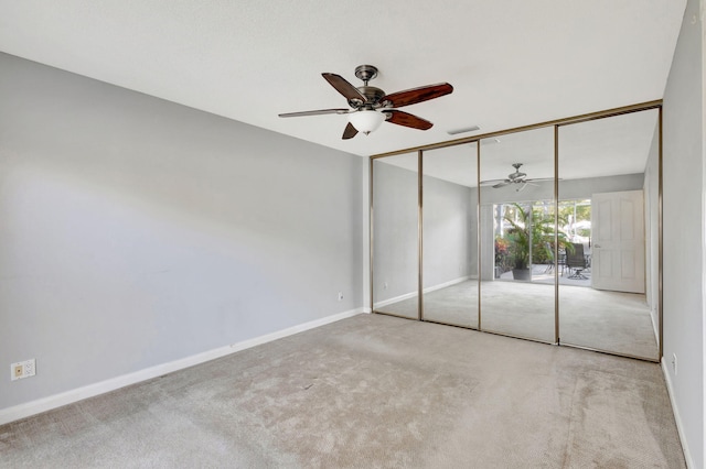 unfurnished bedroom featuring ceiling fan, a closet, and light carpet