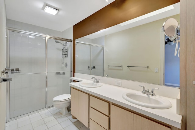 bathroom featuring tile patterned floors, vanity, a shower with shower door, and toilet