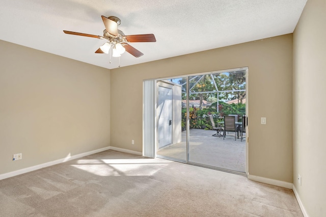 carpeted empty room with ceiling fan and a textured ceiling