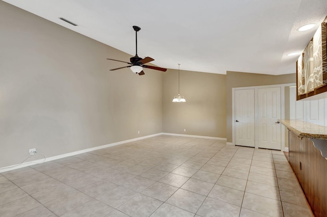 interior space with ceiling fan with notable chandelier and lofted ceiling