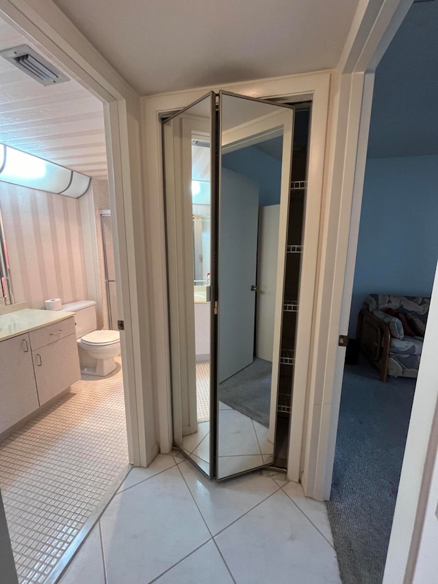 bathroom featuring vanity, toilet, and tile patterned flooring