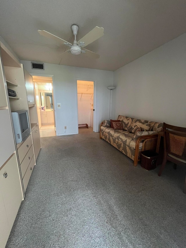 carpeted living room with ceiling fan