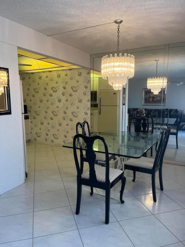 tiled dining room featuring a chandelier and a textured ceiling