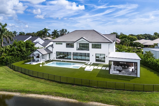 back of property featuring a patio, a lawn, and a fenced in pool