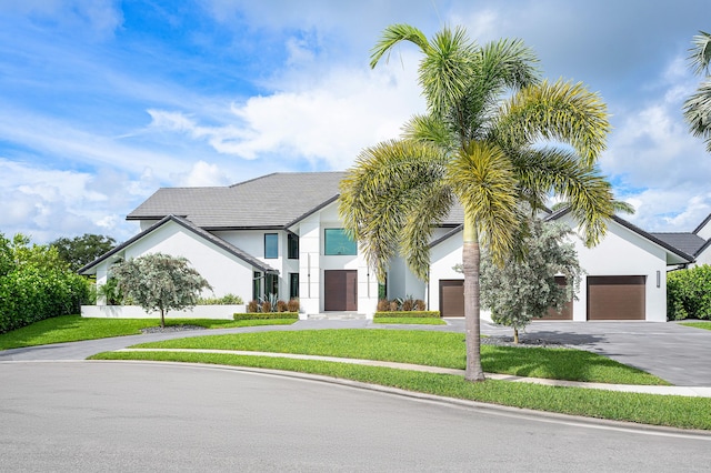 view of front of house with a garage and a front lawn