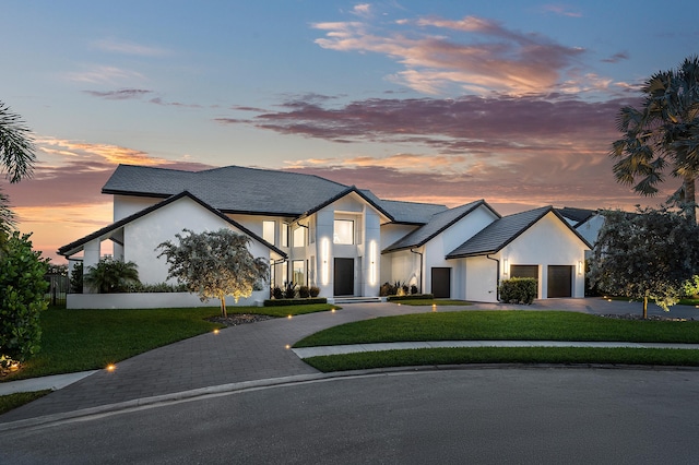 modern farmhouse featuring a garage and a yard