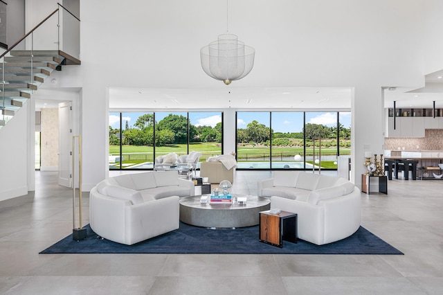 living room featuring light tile patterned flooring, plenty of natural light, and a towering ceiling