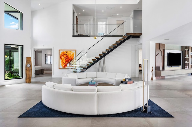 living room with light tile patterned flooring and a towering ceiling