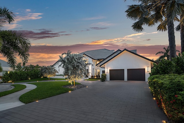 view of front of house with a garage and a yard