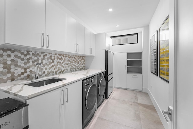 washroom with washing machine and clothes dryer, sink, cabinets, and light tile patterned floors