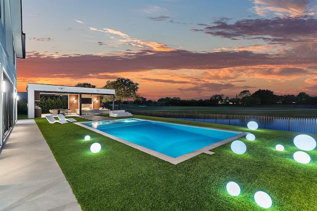 pool at dusk featuring a patio area