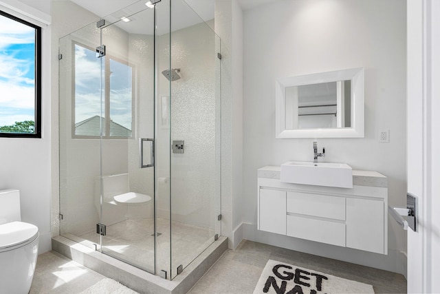 bathroom featuring tile patterned floors, toilet, vanity, and an enclosed shower