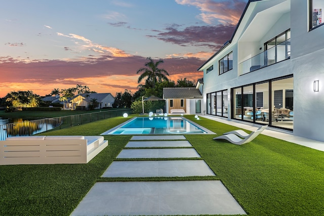 exterior space with a balcony, a patio area, and a fenced in pool