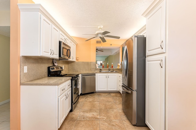 kitchen with white cabinetry, light tile patterned floors, stainless steel appliances, ceiling fan, and decorative backsplash