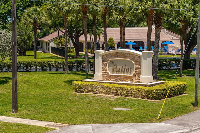 community sign with a yard and a water view