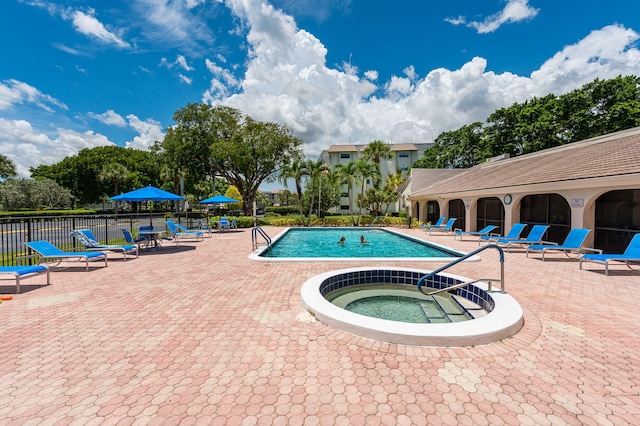 view of swimming pool with a hot tub and a patio area