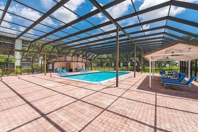 view of swimming pool featuring glass enclosure and a patio