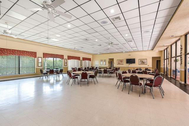 tiled dining space with a paneled ceiling and ceiling fan