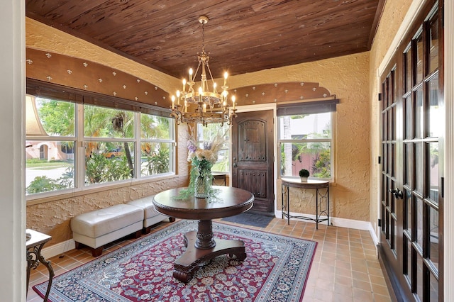 sunroom / solarium featuring a wealth of natural light, lofted ceiling, and a notable chandelier