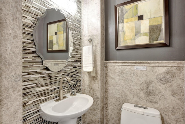 bathroom with tile walls, toilet, and sink