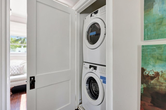 washroom featuring stacked washer and clothes dryer and hardwood / wood-style flooring