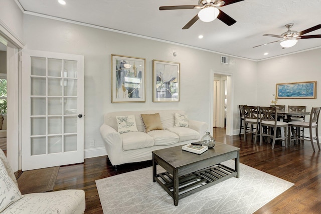 living room with crown molding, dark hardwood / wood-style flooring, and ceiling fan