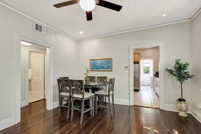 dining space with ceiling fan, ornamental molding, and dark wood-type flooring