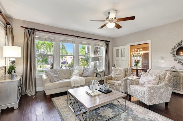 living room featuring ceiling fan with notable chandelier and dark hardwood / wood-style floors