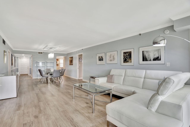 living room with a healthy amount of sunlight, light hardwood / wood-style floors, and ornamental molding