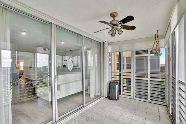 sunroom / solarium with a healthy amount of sunlight and ceiling fan