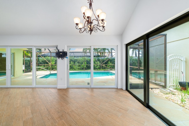 interior space featuring vaulted ceiling, hardwood / wood-style flooring, and a chandelier