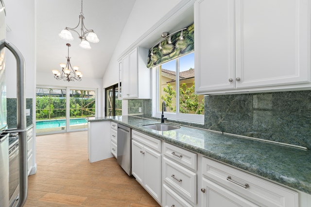 kitchen with backsplash, vaulted ceiling, sink, and plenty of natural light