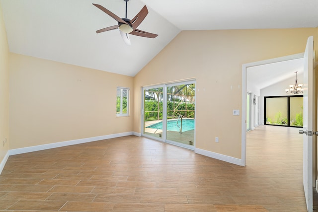 unfurnished room featuring high vaulted ceiling, ceiling fan with notable chandelier, and light hardwood / wood-style floors