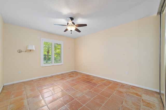 empty room featuring tile patterned flooring and ceiling fan