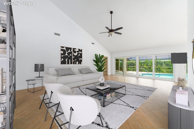 living room with ceiling fan, high vaulted ceiling, and light hardwood / wood-style floors