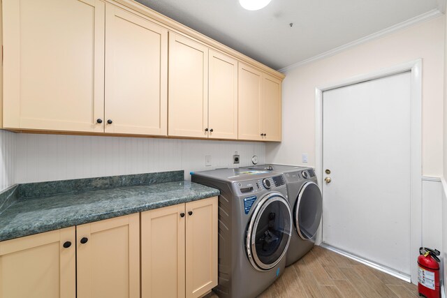 washroom with cabinets, ornamental molding, and independent washer and dryer