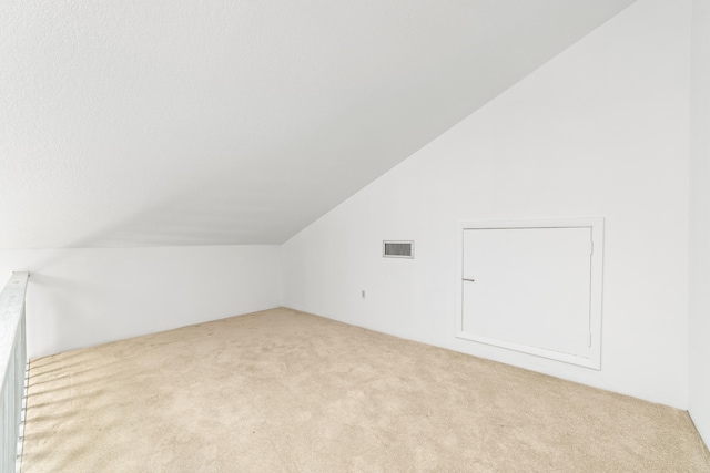 additional living space with lofted ceiling and light carpet