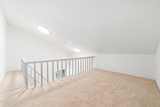 additional living space featuring carpet flooring and vaulted ceiling