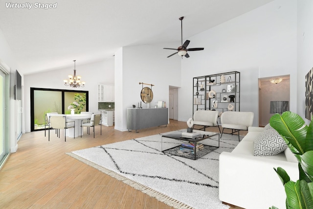 living room featuring high vaulted ceiling, ceiling fan with notable chandelier, and light hardwood / wood-style floors