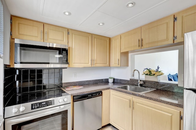 kitchen with stainless steel appliances, light brown cabinetry, and sink