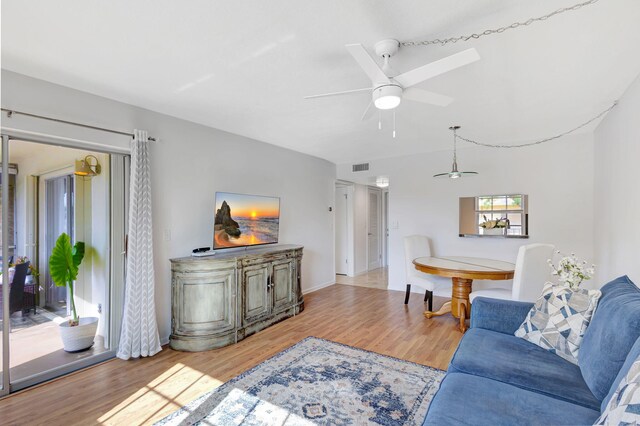 living room featuring light hardwood / wood-style flooring and ceiling fan