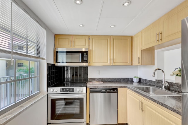 kitchen with light brown cabinetry, appliances with stainless steel finishes, and sink