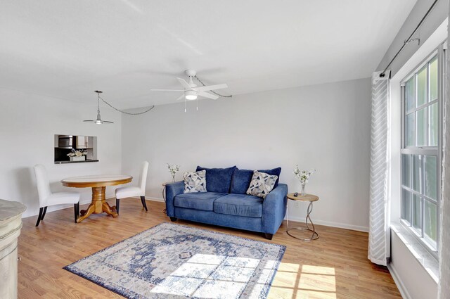 living room featuring ceiling fan and light wood-type flooring