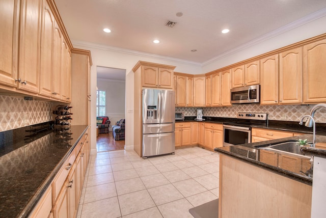 kitchen featuring dark stone countertops, tasteful backsplash, stainless steel appliances, sink, and ornamental molding